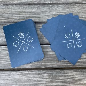 A deck of custom HeartWorks playing cards featuring a heart logo and traditional card symbols, spread out on a wooden surface.