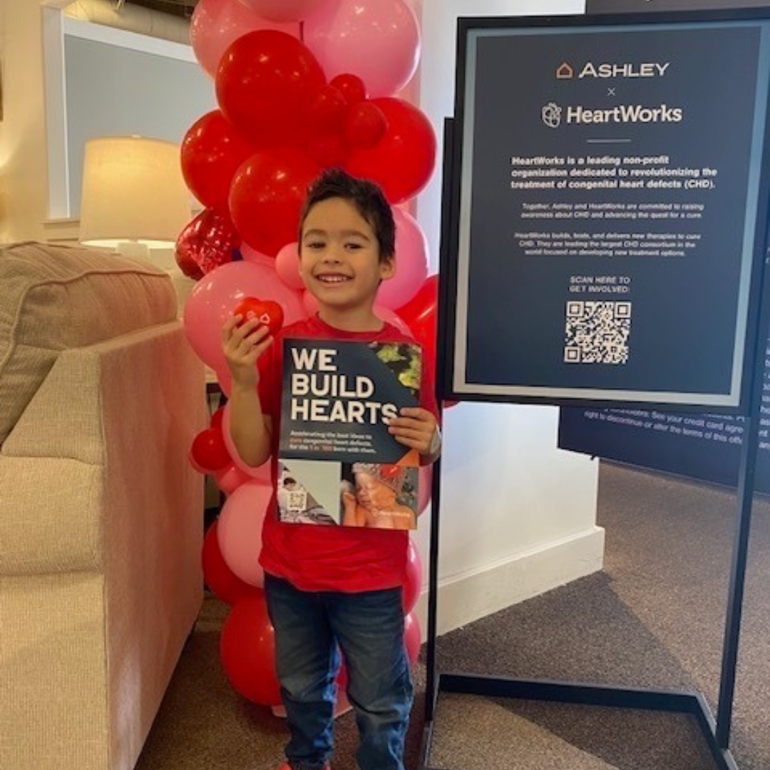 Boy standing in front of signs at furniture store