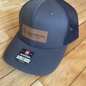 Charcoal and Navy snapback trucker hat with HeartWorks patch