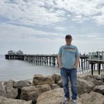 Adam, Director of Clinical Operations, near a pier