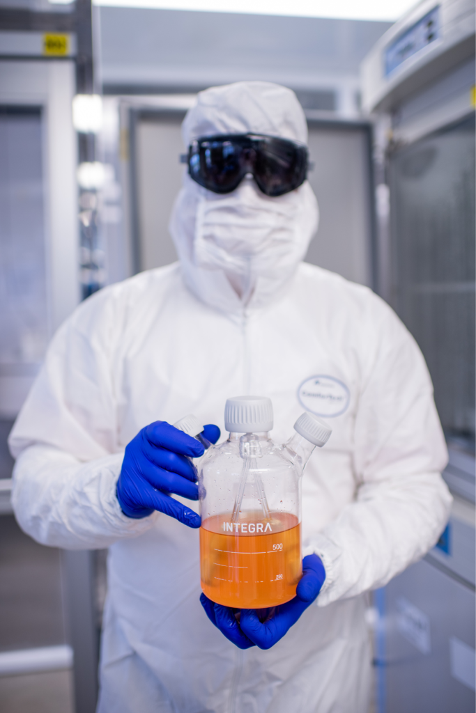 Lab tech holding millions of cardiomyocytes in flask
