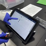HeartWorks lab team member reviewing electronic manufacturing documentation for congenital heart disease cell therapy production